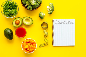 Fototapeta na wymiar Diet program mockup. Start diet text in notebook near vegetables on yellow background top view