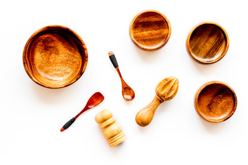 Set of rustic wooden tableware - bowls and utensils on white background top view pattern