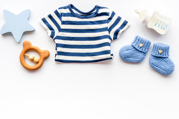Baby background - blue color. Clothes and accessories for newborn boy on white table top-down frame copy space