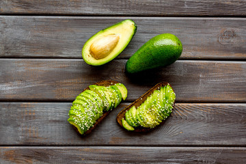 Healthy breakfast. Avocado toast on dark wooden background top view pattern copy space