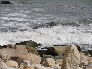 Waves crash and break against rocks