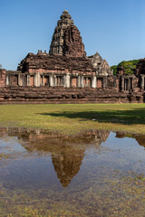 Fototapeta na wymiar The Phimai castle historical park is the largest ancient Khmer temples with reflection in the water. Prasat Hin Phimai beautiful sandstone castle in Thailand.