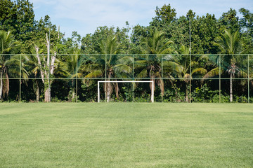 Obraz premium soccer posts in park, field is partially covered in the shadow. Trees in the background are in the sun. Rio de Janeiro, Brazil.