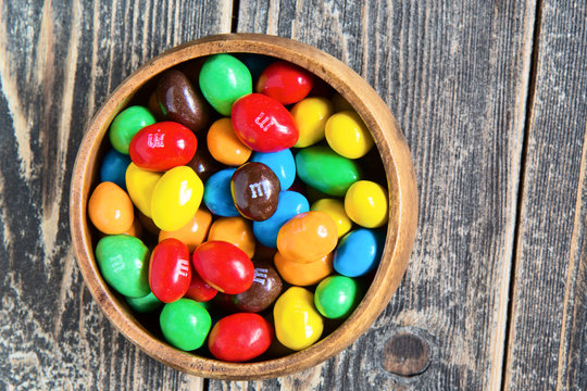 M&M's colorful chocolate candy in a bowl on wooden background. Moscow - October 19, 2019