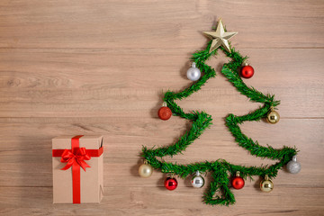 Creative winter layout made with evergreen tree branches and ornament, gift boxes on wooden background