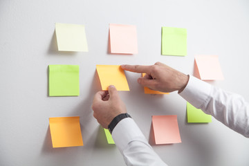 Businessman working with sticky notes in office.