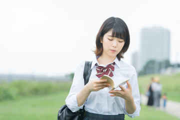 屋外で勉強する女子高生