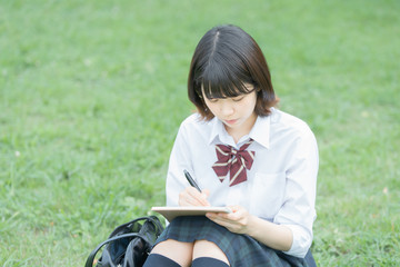 屋外で勉強する女子高生