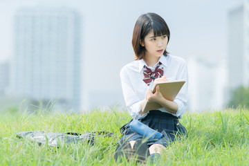 屋外で勉強する女子高生