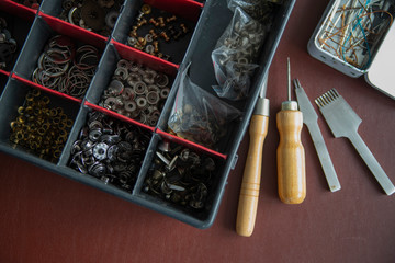 Pins, buttons, and accessories for leather work in box