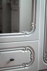 Fragments of white furniture in the old style close-up.