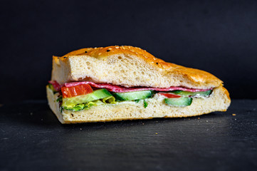 Flatbread sandwich with salami tomato cucumber salad and gravy