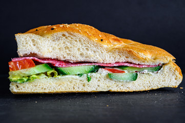 Flatbread sandwich with salami tomato cucumber salad and gravy
