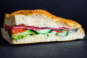 Flatbread sandwich with salami tomato cucumber salad and gravy