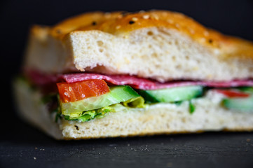 Flatbread sandwich with salami tomato cucumber salad and gravy