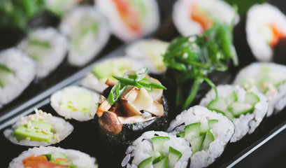 Vegetarian sushi platter with avocado maki, futomaki and mushroom gunkans in the middle.