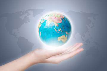 Close-up of a hand holding a globe.