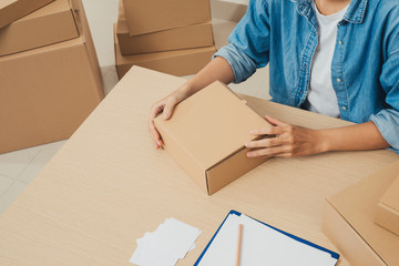 Woman's hand pack products to prepare shipments.