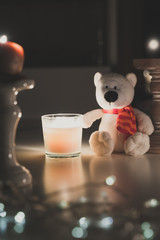 Eisbär sitzt neben einer Kerze