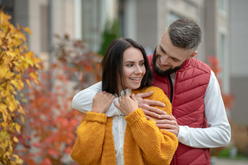 Obraz premium Positive young man hugging his beloved girlfriend