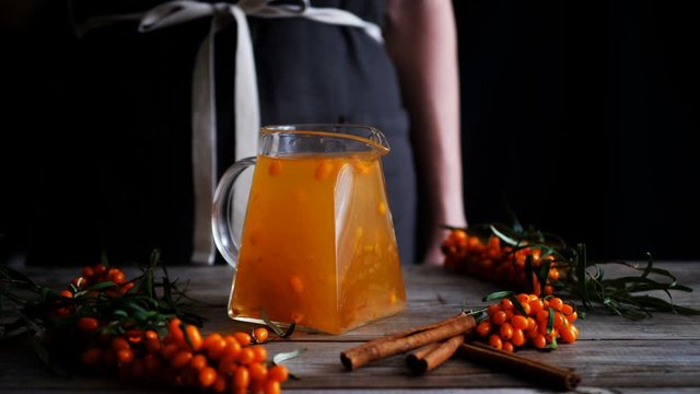 Glass teapot with herbal sea buckthorn tea. Seamless cinemagraph looped video