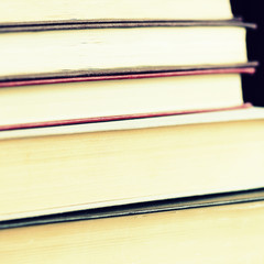 Old books stacked closeup. Toned educational background, square shape