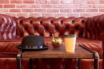 Black hat and glass cup with coffee on the table. British style