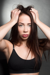 Studio emotional portrait of a brunette girl in dark colors