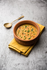 Vegetable masala oats khichadi served in a bowl. selective focus