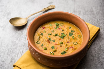 Vegetable masala oats khichadi served in a bowl. selective focus