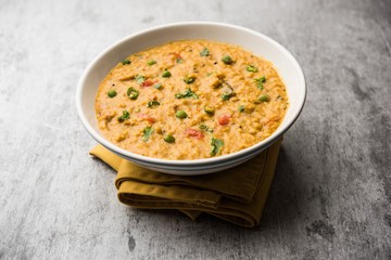 Vegetable masala oats khichadi served in a bowl. selective focus