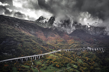 High autumn alpine speed road in Italia. Aerial view from above with clouds on the background