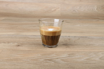 Macchiato Coffee Cup - Coffee in a black cup isolated on a wooden background - Cappuccino Latte Espresso   