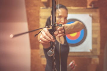 Young beautiful woman in sports competitions, archery, aiming at the target