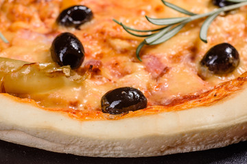 Tasty fresh hot pizza against a dark background. Pizza, food, vegetable, mushrooms.  It can be used as a background