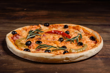 Tasty fresh hot pizza against a dark background. Pizza, food, vegetable, mushrooms.  It can be used as a background