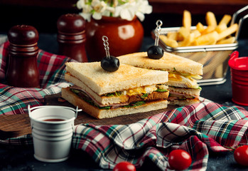 club sandwich with ham in crispy bread and french fries