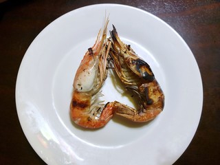 Top view of barbecued shrimp in white plate on wooden table in restaurant, Ready to serve or eat, Copy space, Shaped like a heart