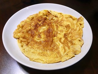 Top view of omelet in white plate on wooden table as a background, Space for text in template, Ready to eat