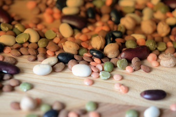 Fototapeta na wymiar Different beans scattered on a wooden surface close-up. Naturel organic food background