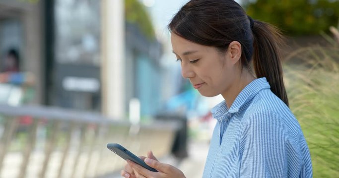 Woman check on smart phone in city