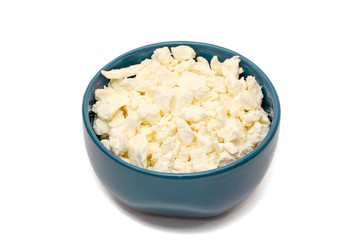 Fresh organic cottage cheese in blue ceramic bowl on a white background. Concept of healthy dairy products. Protein rich foods. Closeup. Copy space