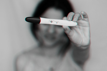 positive pregnancy test in hands of happy pregnant girl