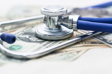 The blue stethoscope sits on the jumbled dollar