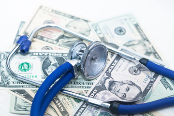 The blue stethoscope sits on the jumbled dollar