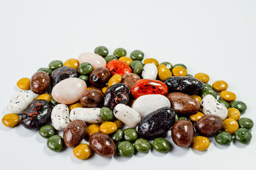 Pebble-dragee with apricots, chocolate, mandarin and marzipan. Tasty, bright, shot on a white background.