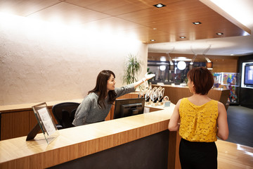 カウンターで来訪者の案内をする女性