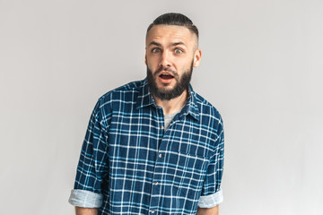 Freestyle. Guy in checkered shirt standing isolated on white looking camera surprised