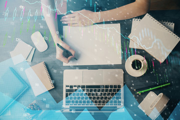 Financial graph displayed on woman's hand taking notes background. Concept of research. Multi exposure