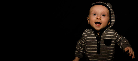 A 4 Month Old Baby Poses on a Black Background. Perfect for Memes with Copy Space.
